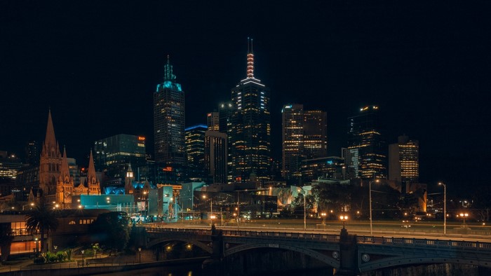 Night cityscape with illuminated skyscrapers and bridge