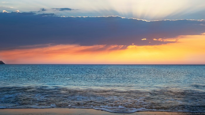 Sunset over the ocean with dramatic clouds