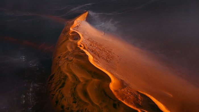 Aerial view of a desert dune with water