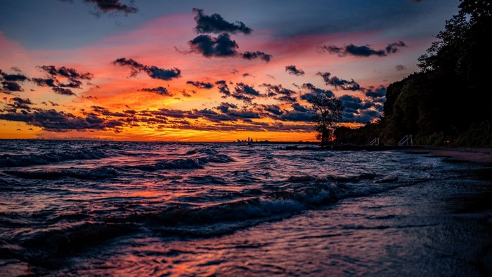 Sunset over the ocean with a distant city skyline
