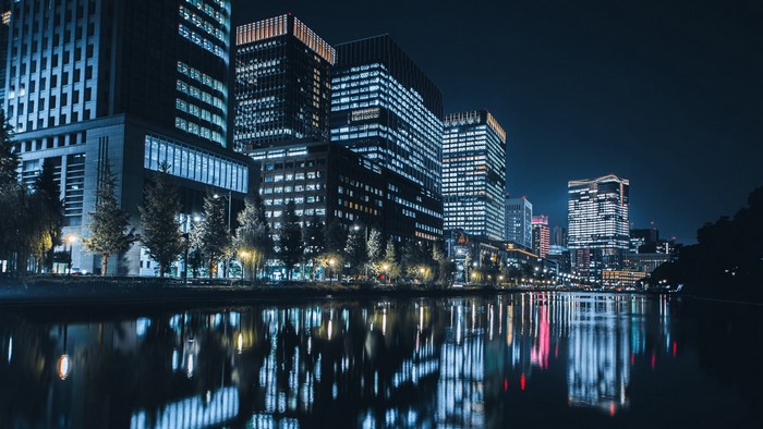 Night city skyline with reflections in water