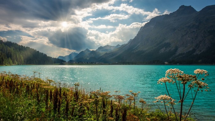 Turquoise lake with mountains and sunbeams