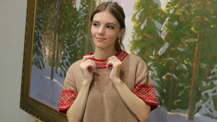 Woman in traditional clothing in front of a painting