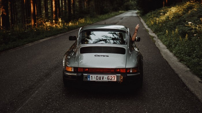 Porsche Carrera driving on a forest road