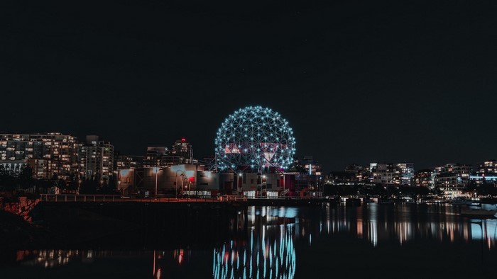 Science World at night with city skyline and water reflection