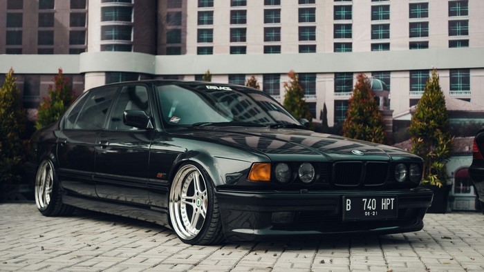 Black BMW 740i E38 on a paved surface