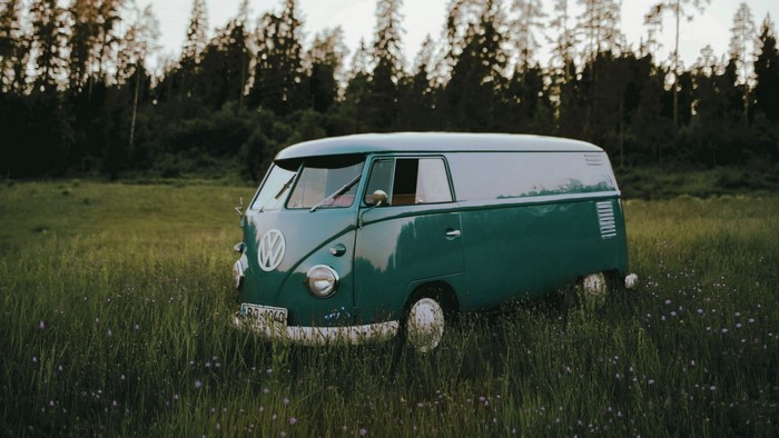Green Volkswagen T1 van in a grassy field