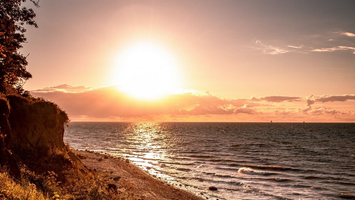 Sunset over the ocean with a cliffside