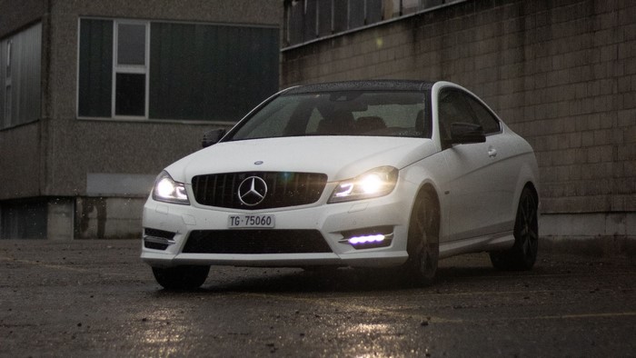 White Mercedes-Benz C250 AMG Coupe on Wet Pavement