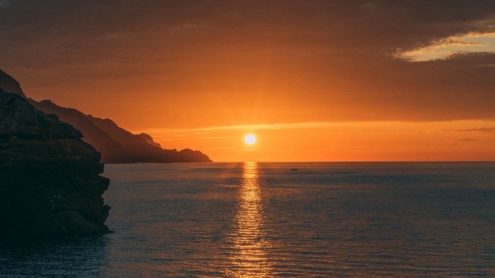 Sunset over the ocean with mountains