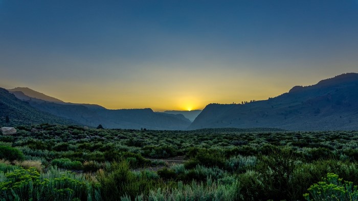 Sunset over a valley with mountains and sagebrush