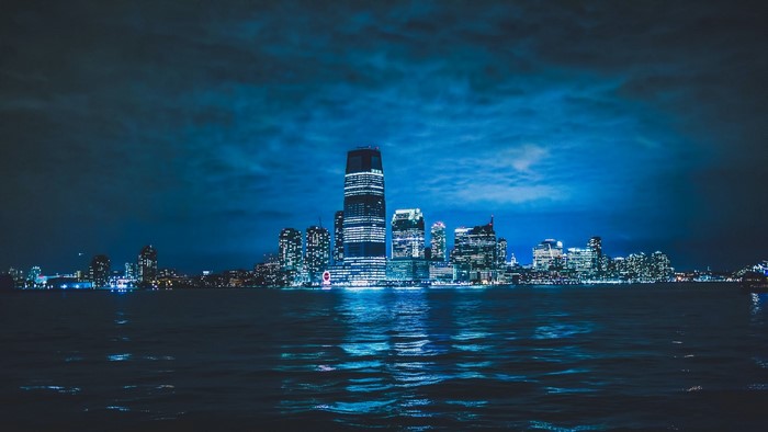 Night cityscape with illuminated skyscrapers reflected in water