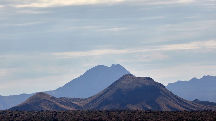 Hills and mountains under a cloudy sky