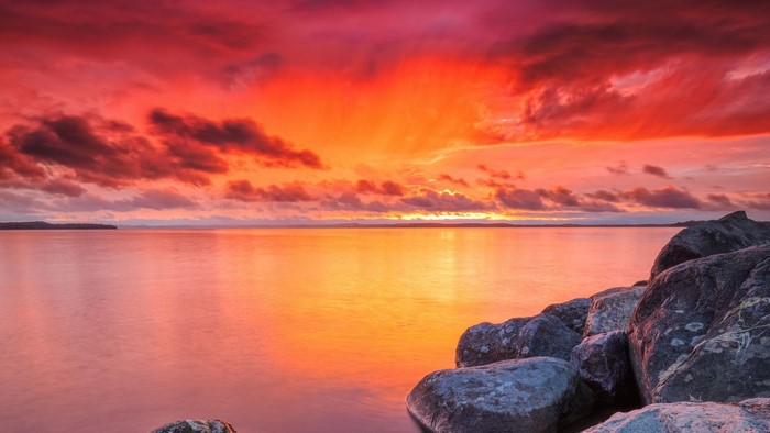 Sunset over a calm lake with rocks
