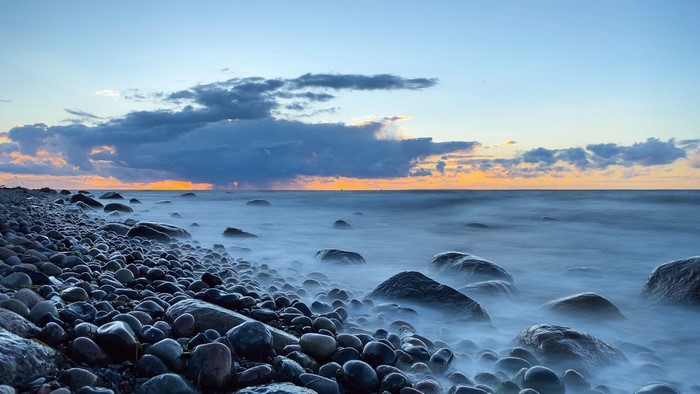 Rocky coast with ocean waves at sunset