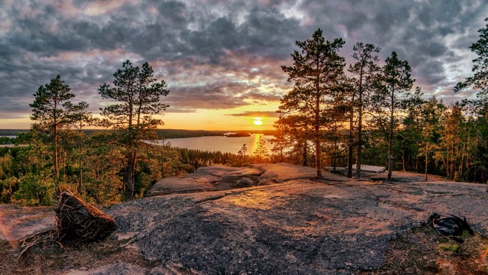 Sunset over a lake with trees on a rocky outcrop