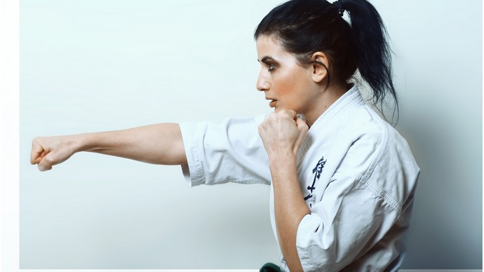 Woman in Karate Gi Performing a Punch