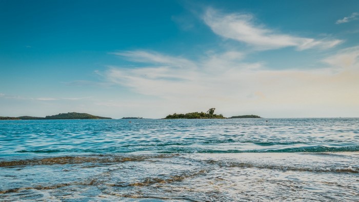 Ocean waves with islands and blue sky