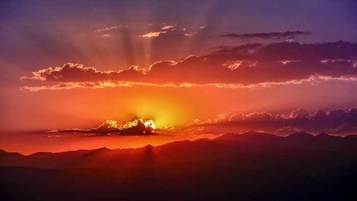 Sunset over mountains with sun rays