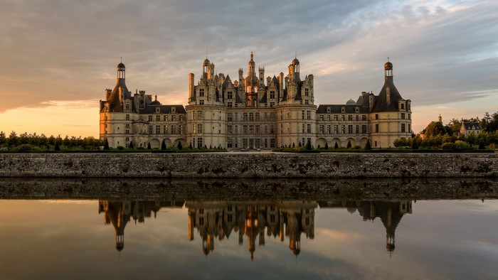 Chateau de Chambord reflected in the water at sunset