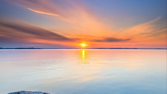 Sunset over a calm body of water with colorful clouds