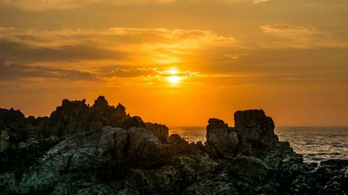 Sunset over rocky coast with ocean