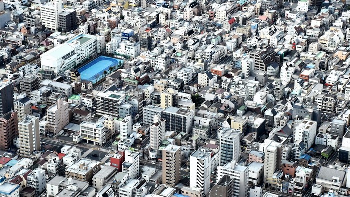 Urban landscape with dense buildings and a sports field