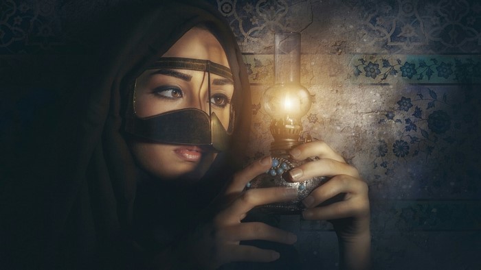Woman in traditional attire holding an oil lamp