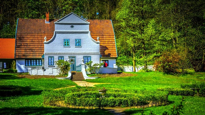 White house with orange roof in a garden