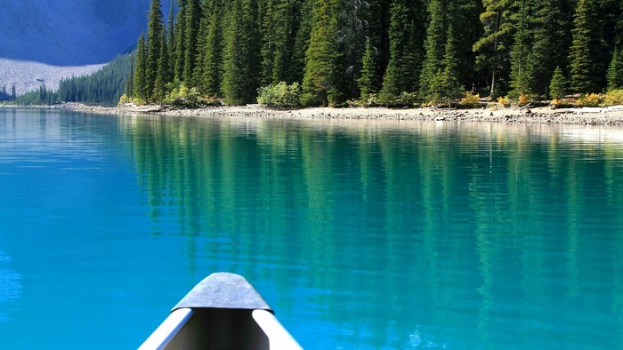 Canoe on a Turquoise Lake with Pine Forest