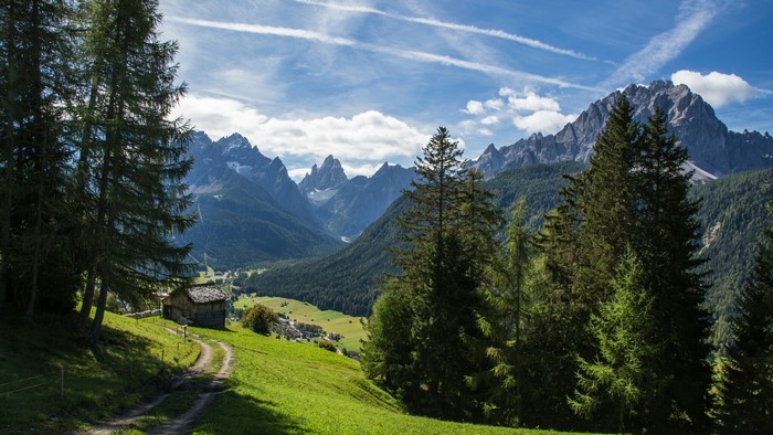 Mountain valley with a small cabin and trees