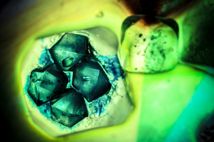 Macro shot of teal ice cubes with blue liquid