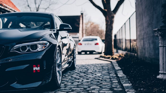Black BMW M2 parked on cobblestone street