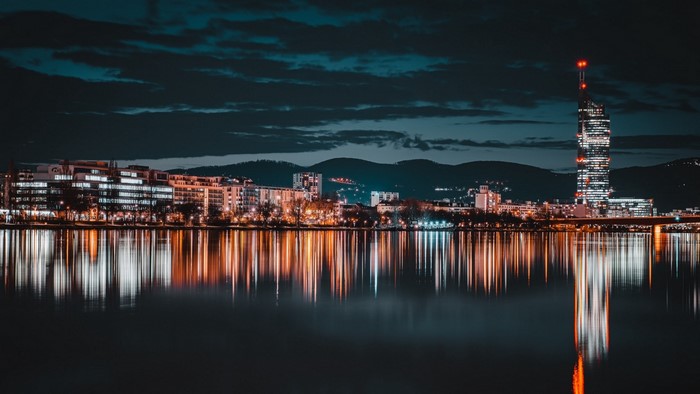 Night city skyline with river reflections