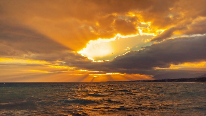 Sunset over the ocean with dramatic clouds