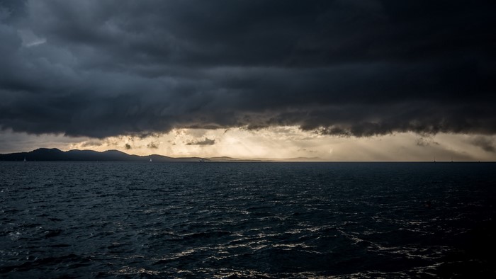 Dark storm clouds over the ocean horizon