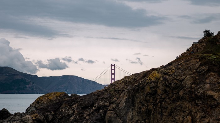Golden Gate Bridge behind rocky cliffs
