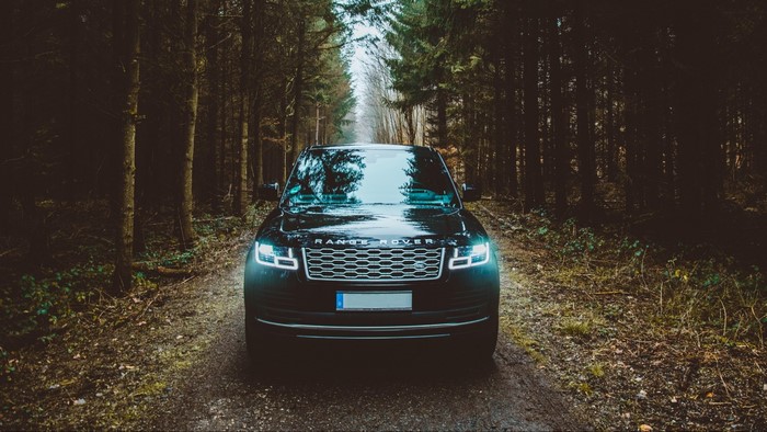 Black Range Rover on a forest road