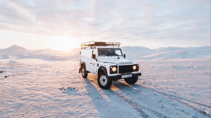 White Land Rover Defender in Snowy Landscape