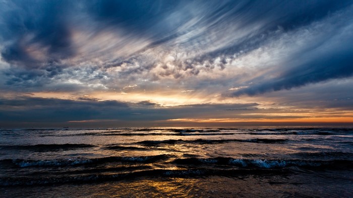 Waves crashing on a beach at sunset
