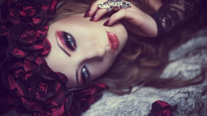 Woman with dark red roses and dramatic makeup