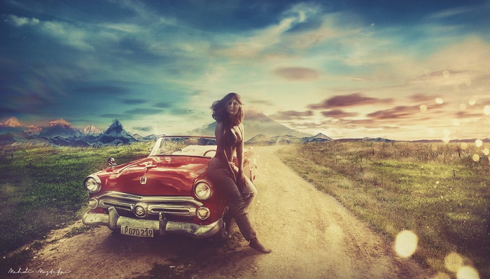 Woman leaning on a vintage red car in a landscape
