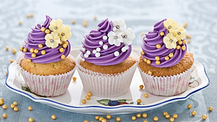Three decorated cupcakes on a platter