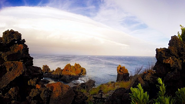 Rocky coastline overlooking the sea under a cloudy sky