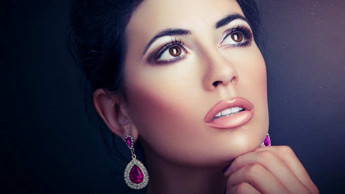 Woman with pink earrings and makeup