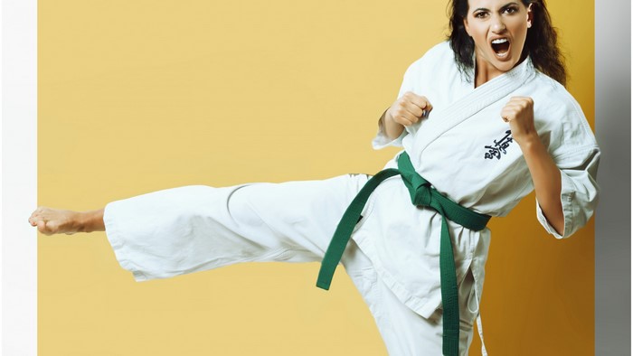 Woman in Karate Gi Performing a Kick