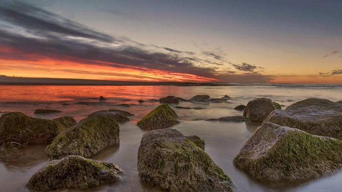 Sunset over the ocean with rocks