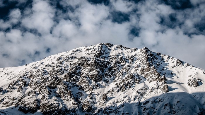 Snowy Mountain Peak Under Cloudy Sky