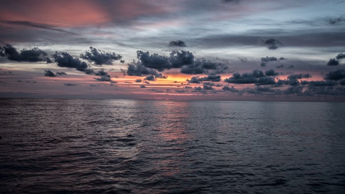 Sunset over the ocean with clouds