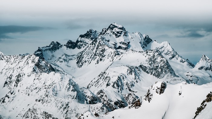 Snow-covered mountain range under a cloudy sky